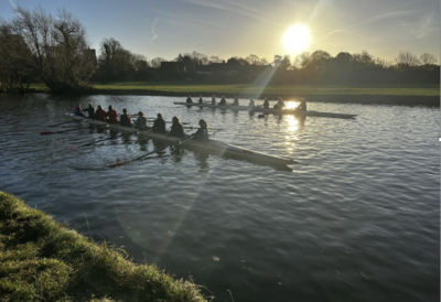 An image of a rowing boat on the river in the early morning sun